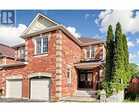 A red brick house with a white garage door and a black gate.