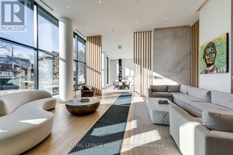 A modern living room with white furniture and a large window.