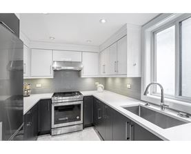 A modern kitchen with a stove top oven and a sink.