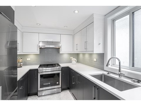 A modern kitchen with a stove top oven and a sink.