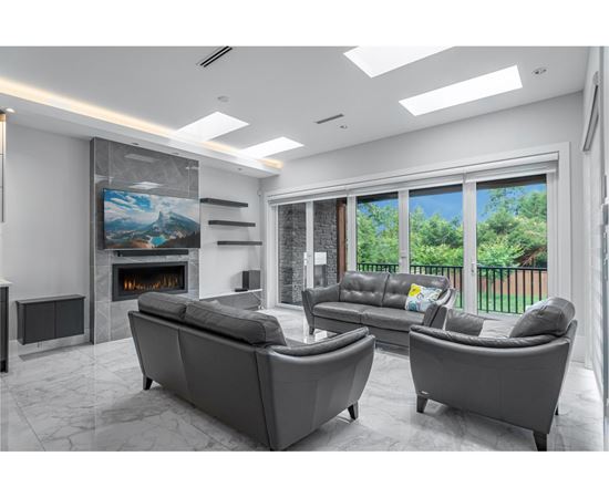 A modern living room with a fireplace and a large painting on the wall.