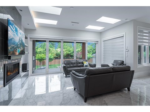 A modern living room with a grey sofa and a fireplace.