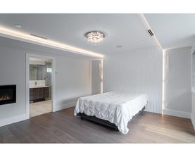A bedroom with a large bed and a fireplace.