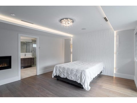 A bedroom with a large bed and a fireplace.