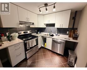 A kitchen with white cabinets and a black stove top oven.