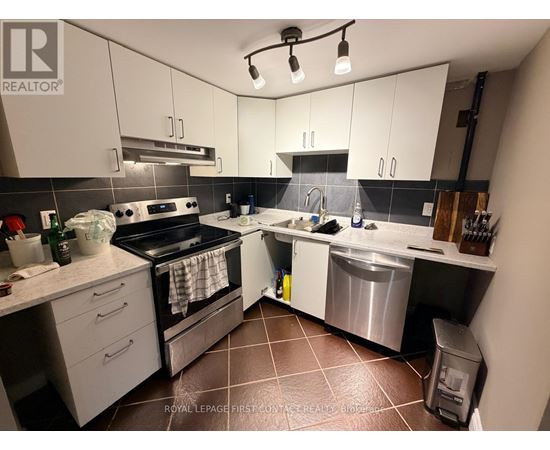 A kitchen with white cabinets and a black stove top oven.