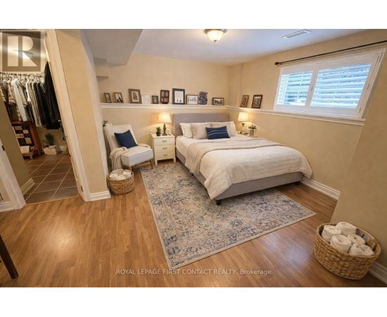 A bedroom with a large bed and a wooden floor.