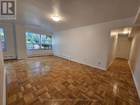 A room with wooden flooring and white walls.