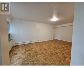 A room with wooden flooring and white walls.