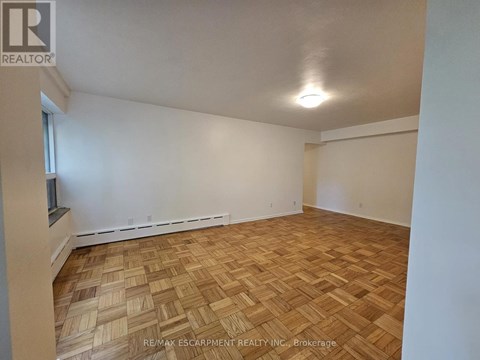 A room with wooden flooring and white walls.