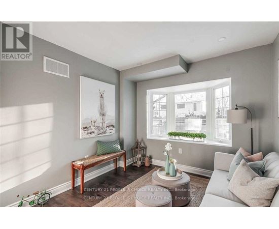 A living room with a grey couch, a wooden bench, and a painting of a deer on the wall.
