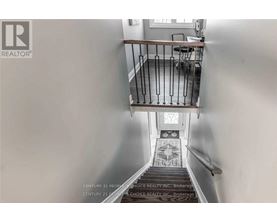 A staircase with a metal railing and a tiled floor.