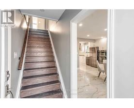 A staircase with wooden steps leads to a brightly lit room.