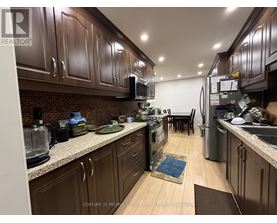 A kitchen with brown cabinets and a brick backsplash.