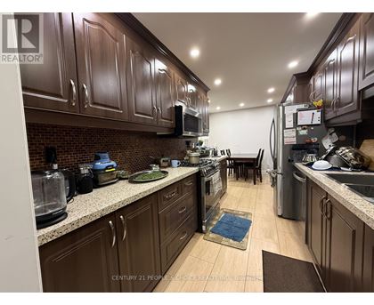 A kitchen with brown cabinets and a brick backsplash.