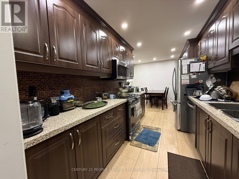 A kitchen with brown cabinets and a brick backsplash.