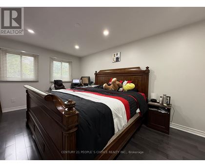 A bedroom with a large bed and a teddy bear on it.