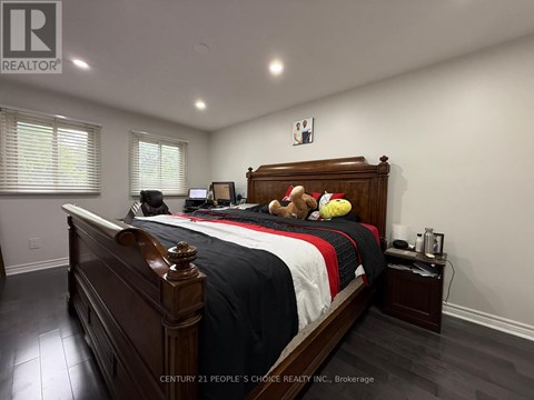 A bedroom with a large bed and a teddy bear on it.