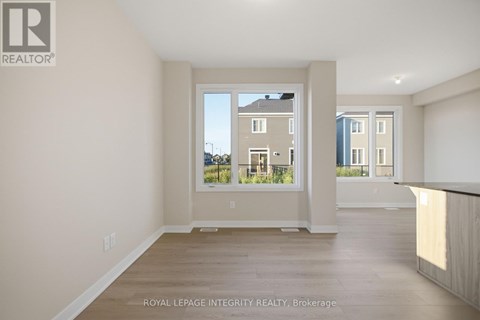 A white room with a window showing a view of a building across the street.