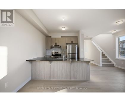 A modern kitchen with a stainless steel refrigerator and a wooden island.