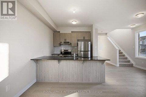A modern kitchen with a stainless steel refrigerator and a wooden island.