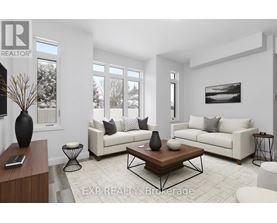 A living room with a white couch, a coffee table, and a large window.