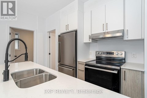 A kitchen with white cabinets and stainless steel appliances.