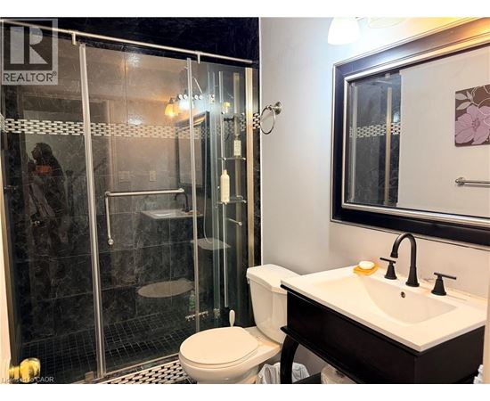 A bathroom with a toilet, sink, and shower.