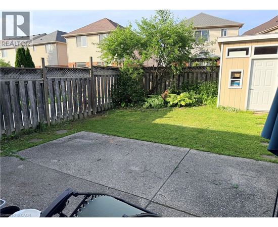 A backyard with a fence and a small shed.