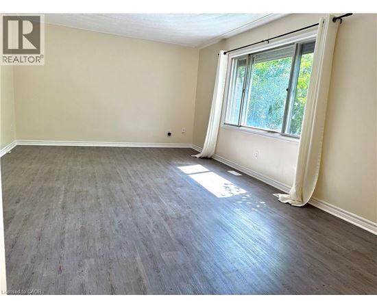 A room with a window and wooden flooring.