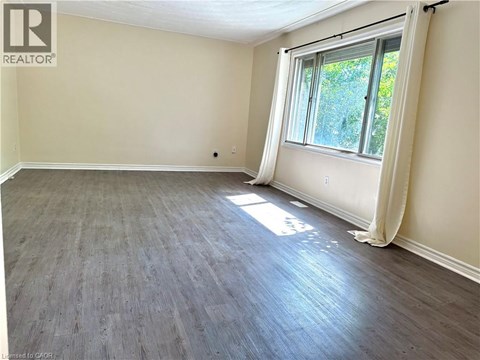 A room with a window and wooden flooring.