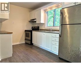 A kitchen with a refrigerator, oven, and sink.