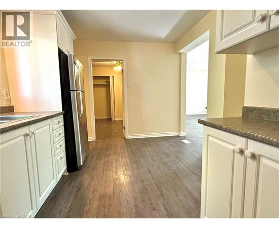 A kitchen with a refrigerator and cabinets.