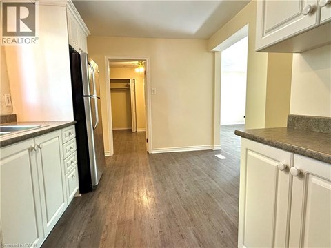 A kitchen with a refrigerator and cabinets.