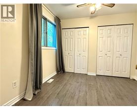 A room with a window, two doors, and a ceiling fan.