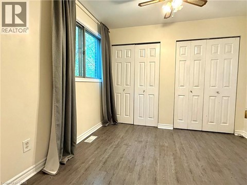 A room with a window, two doors, and a ceiling fan.