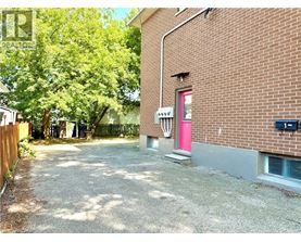A red door is on the side of a brick building.
