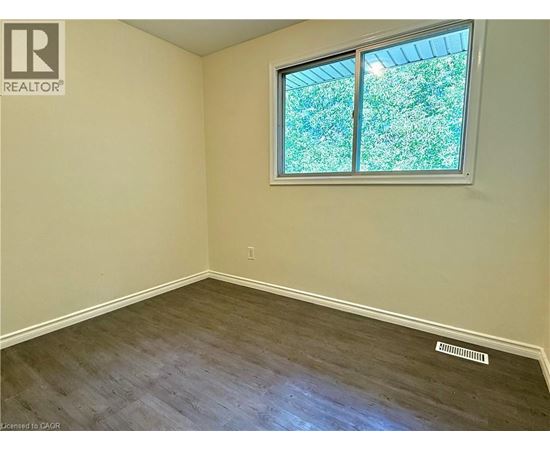 A room with a window showing greenery outside.