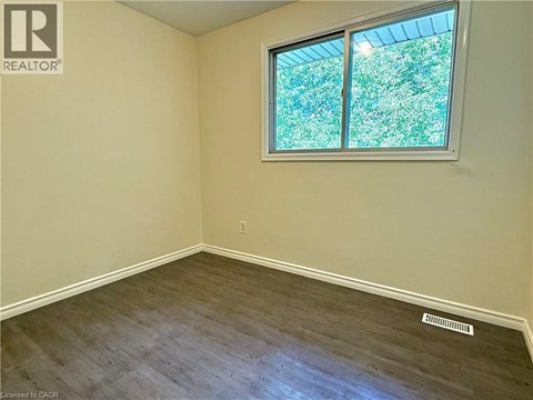 A room with a window showing greenery outside.
