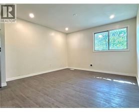 A room with a window and a wooden floor.