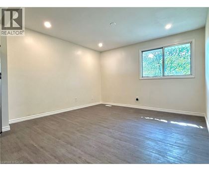 A room with a window and a wooden floor.