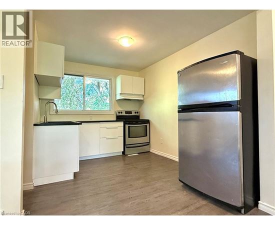 A kitchen with a refrigerator on the right side.