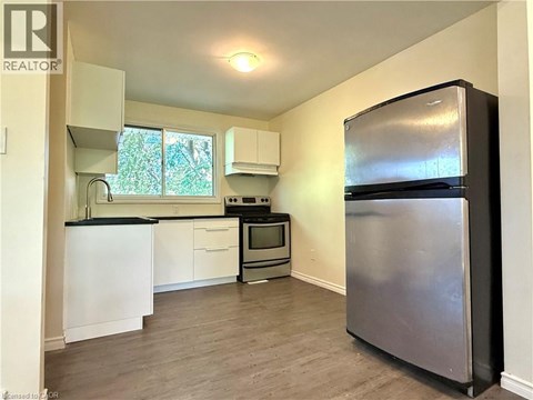 A kitchen with a refrigerator on the right side.