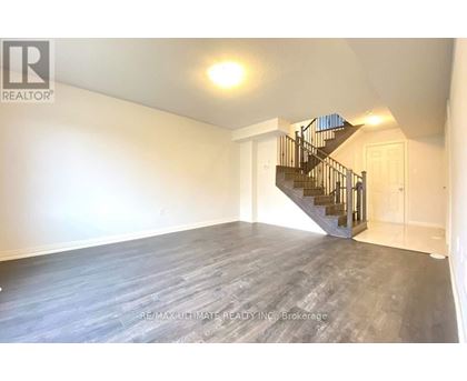 A spacious room with a staircase leading to another floor.