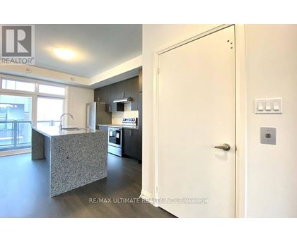 A kitchen with a refrigerator, microwave, and oven.