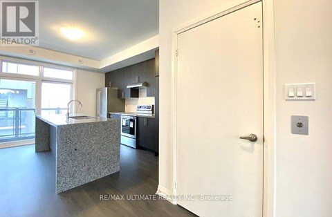 A kitchen with a refrigerator, microwave, and oven.