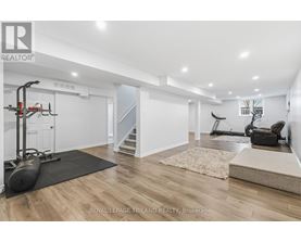 A spacious room with a black exercise bike and a black chair.