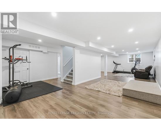 A spacious room with a black exercise bike and a black chair.