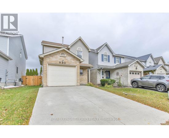 A house with a garage and a car parked in front.