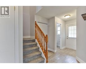 A hallway with a staircase and a door.